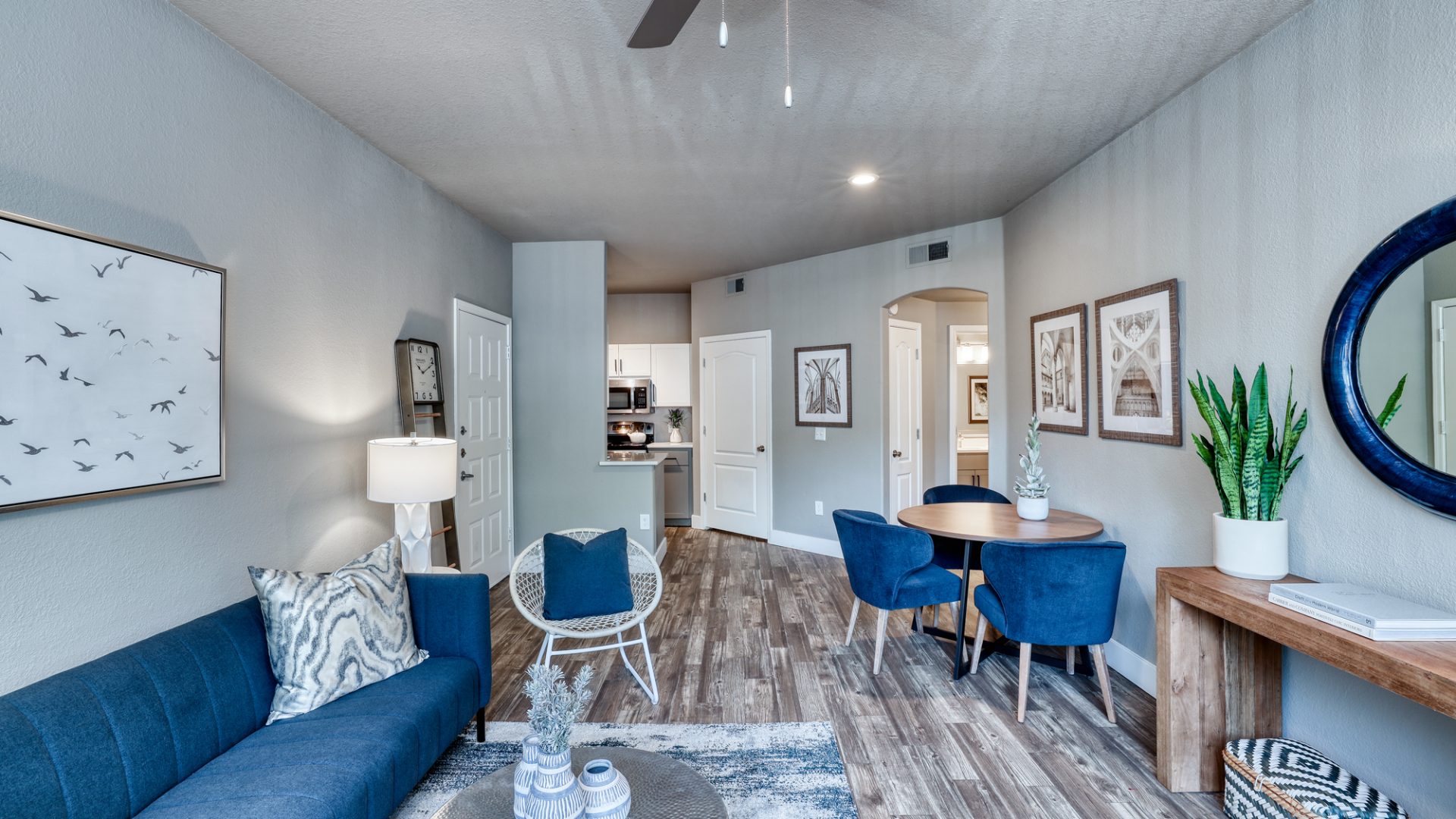 a living room with blue furniture and a ceiling fan at The Oxford