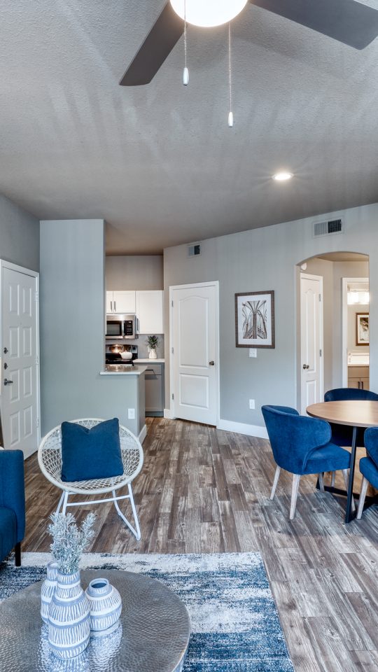a living room with blue furniture and a ceiling fan at The Oxford